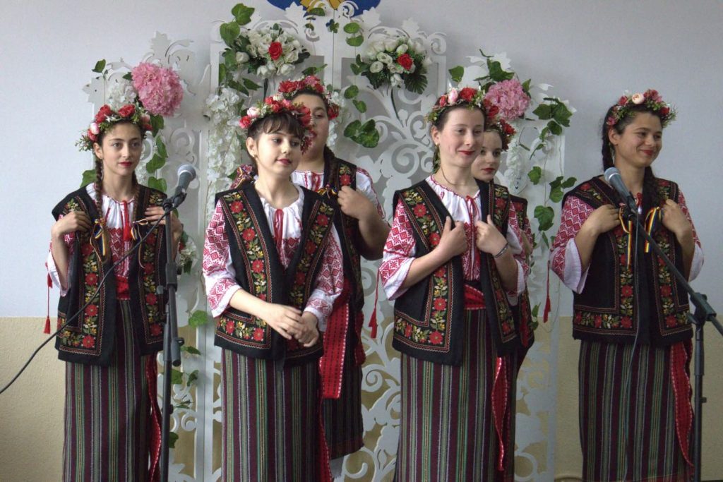 Eleve în costume populare cântând