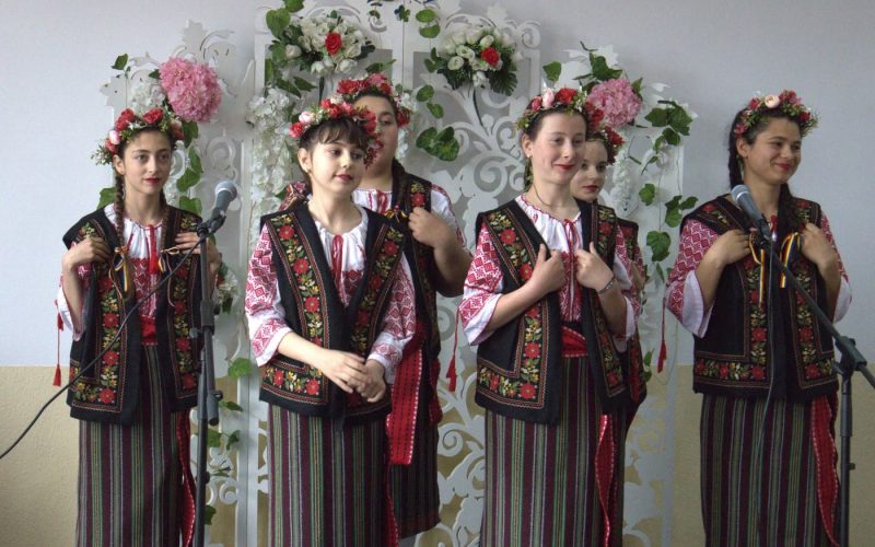 Eleve în costume populare cântând
